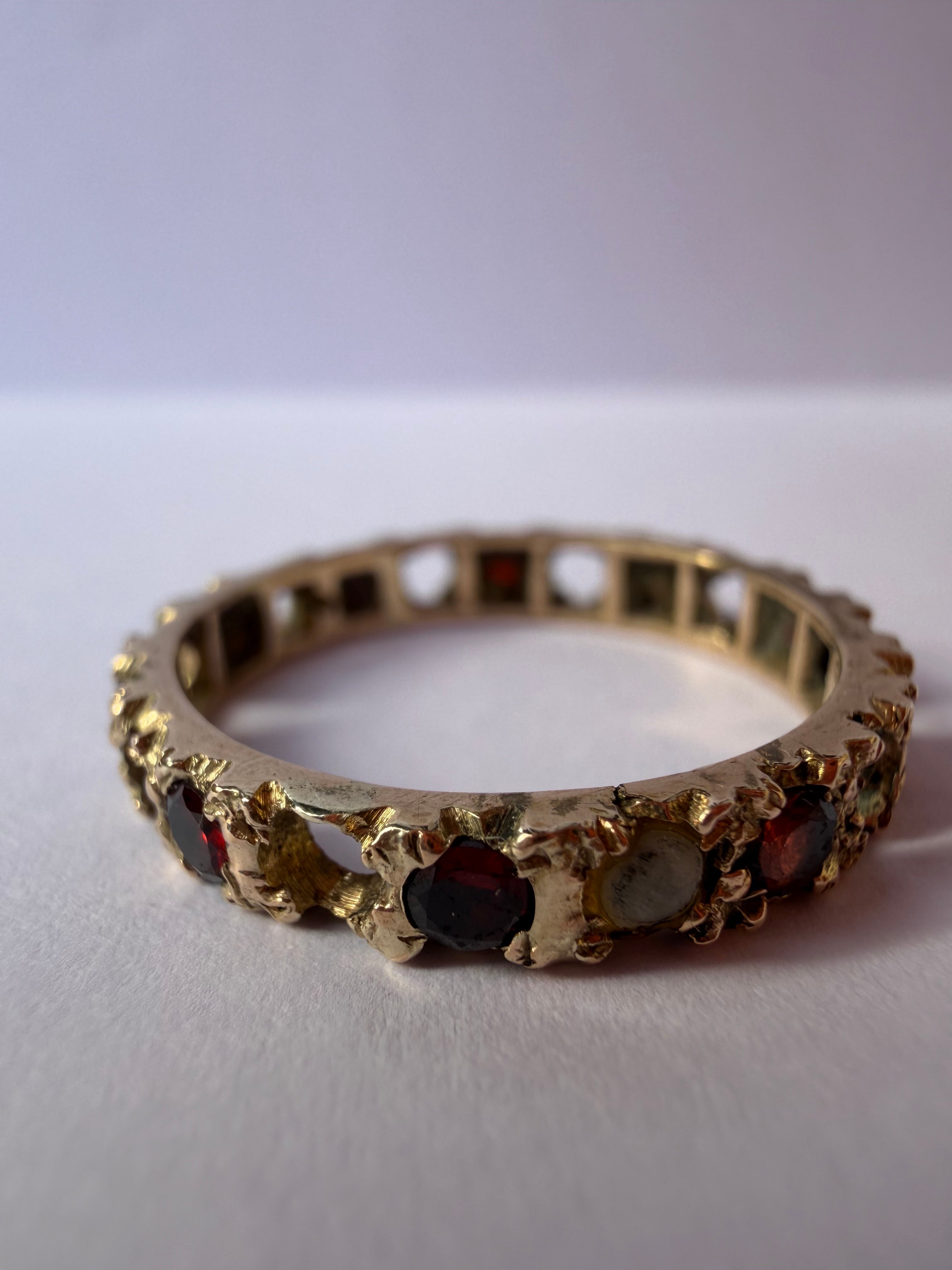 Lot 28: 9ct gold eternity ring with garnet
